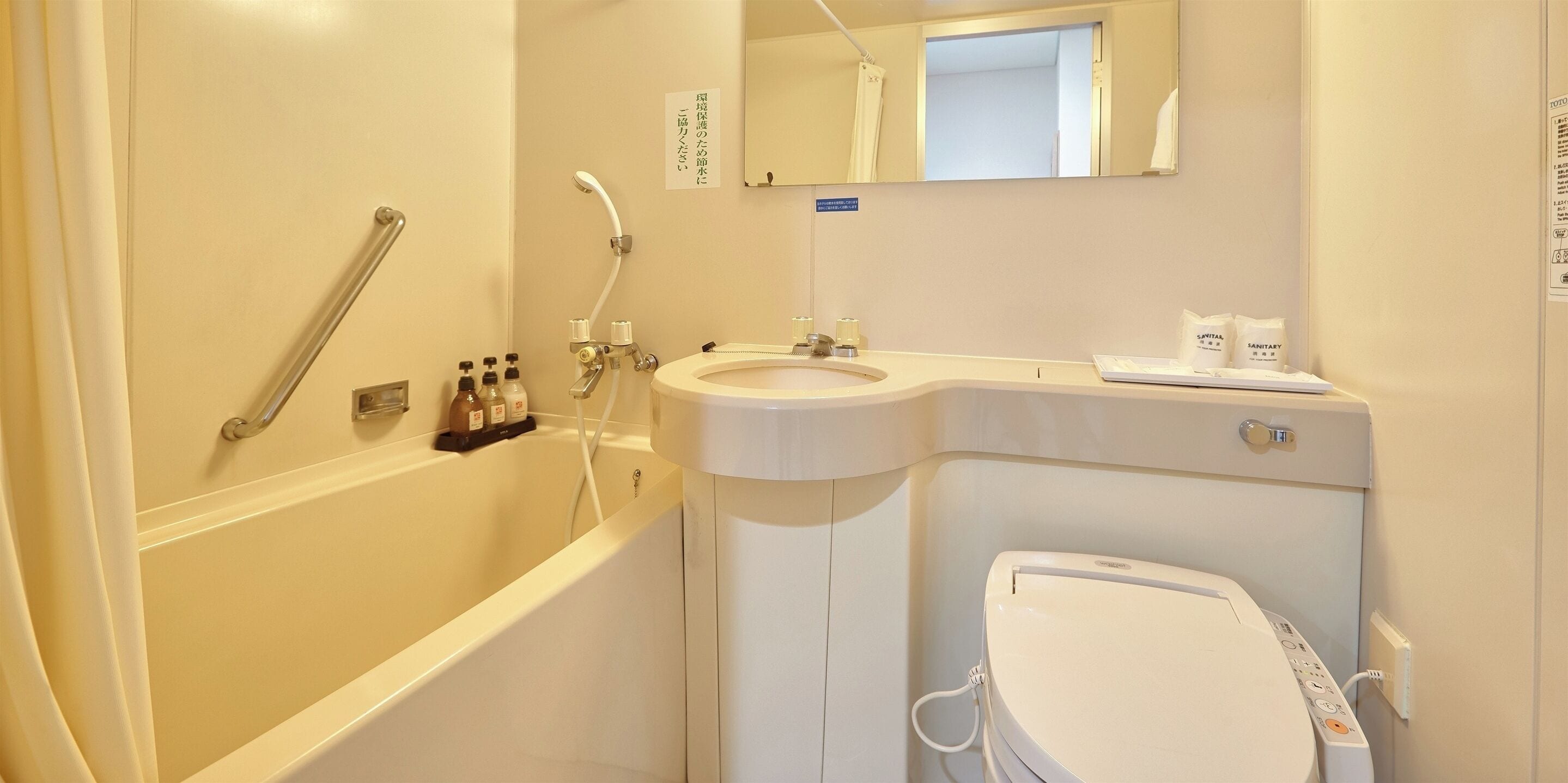 A bathroom with a bathtub, toilet, sink, and a mirror.