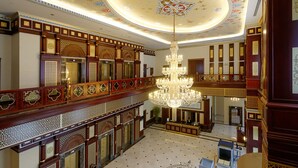 A grand hall with ornate woodwork, a large chandelier, and a decorative ceiling. - Meyra Palace (Ankara)