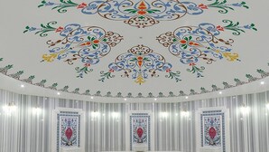 A spacious room with a marble floor, a central round table, and a decorative ceiling with intricate patterns. - Meyra Palace (Ankara)