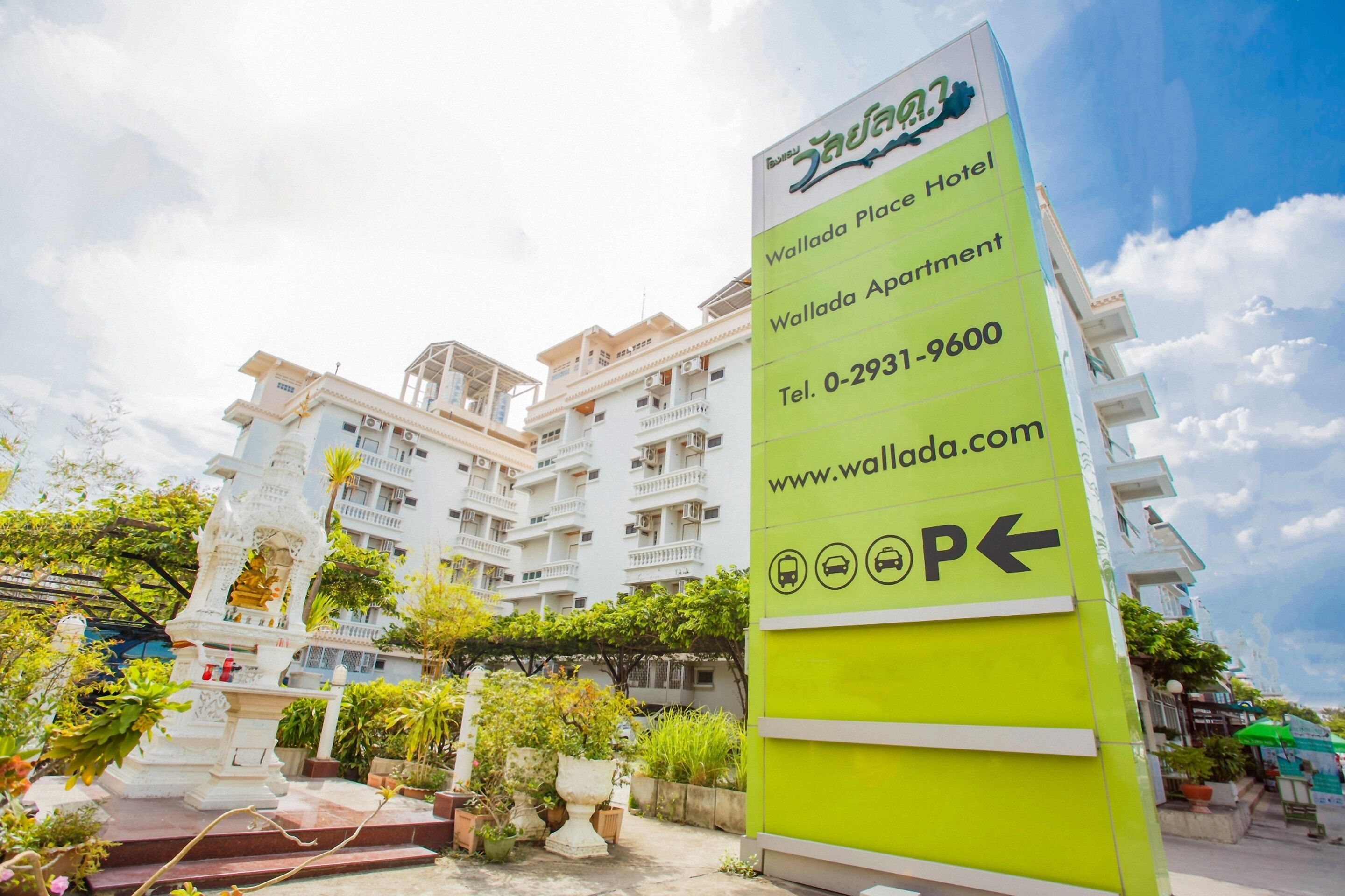 A hotel sign with the name "Wallada Place Hotel" and contact information.
