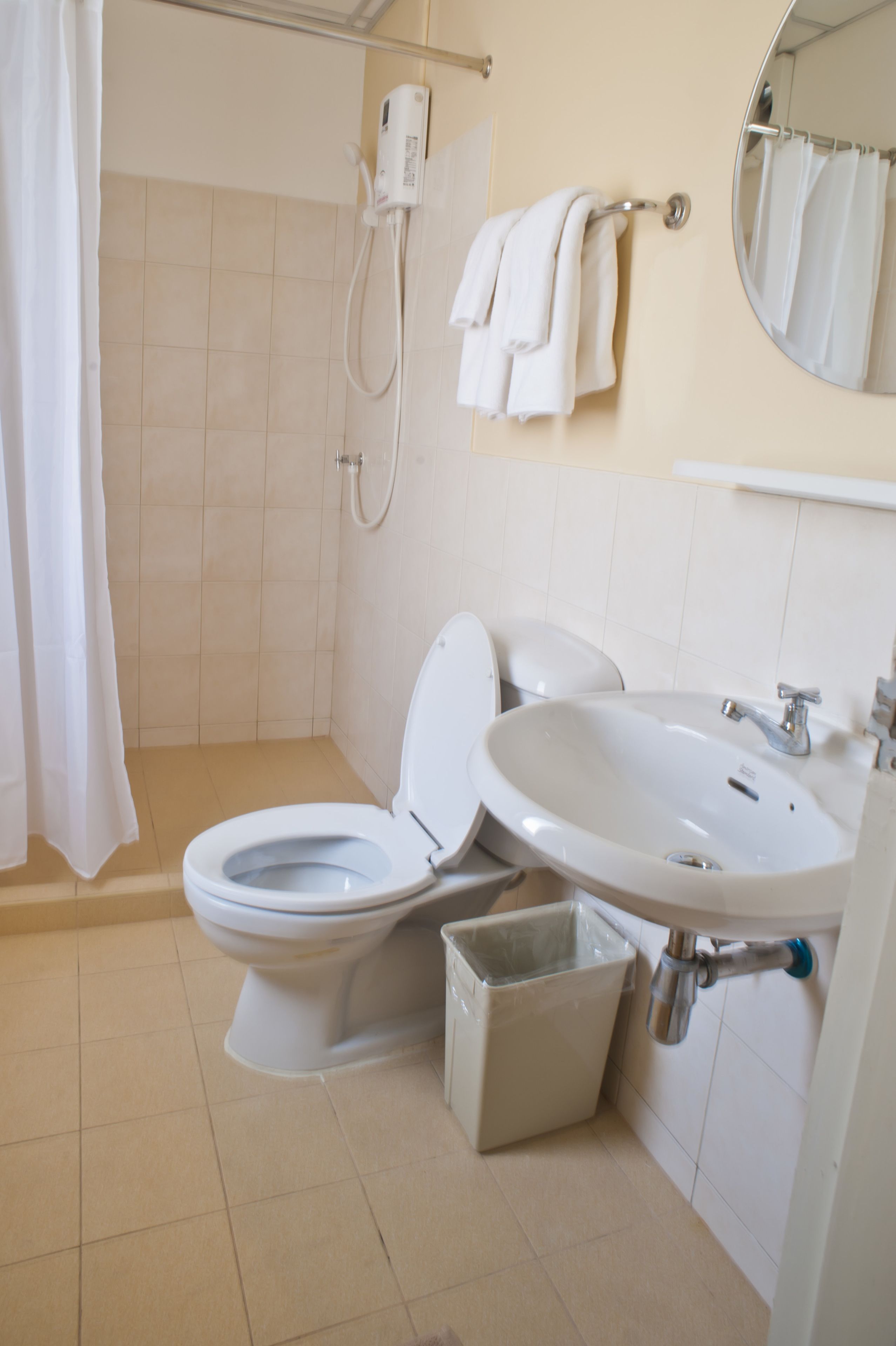 A bathroom with a toilet, sink, and shower.