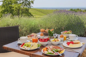 Café da manhã ao ar livre com diversas opções de comida e uma vista panorâmica.