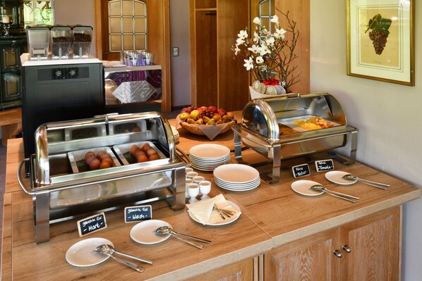 A buffet setup with various food items and utensils. - Hotel Rebenhof (Baden-Baden)