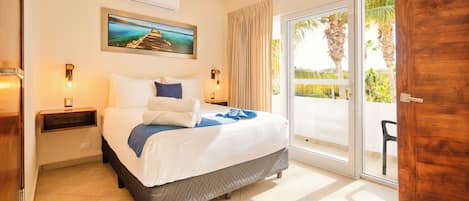 A hotel room with a bed, a nightstand, an air conditioning unit, a ceiling fan, a sliding glass door to the outside, and a painting on the wall.