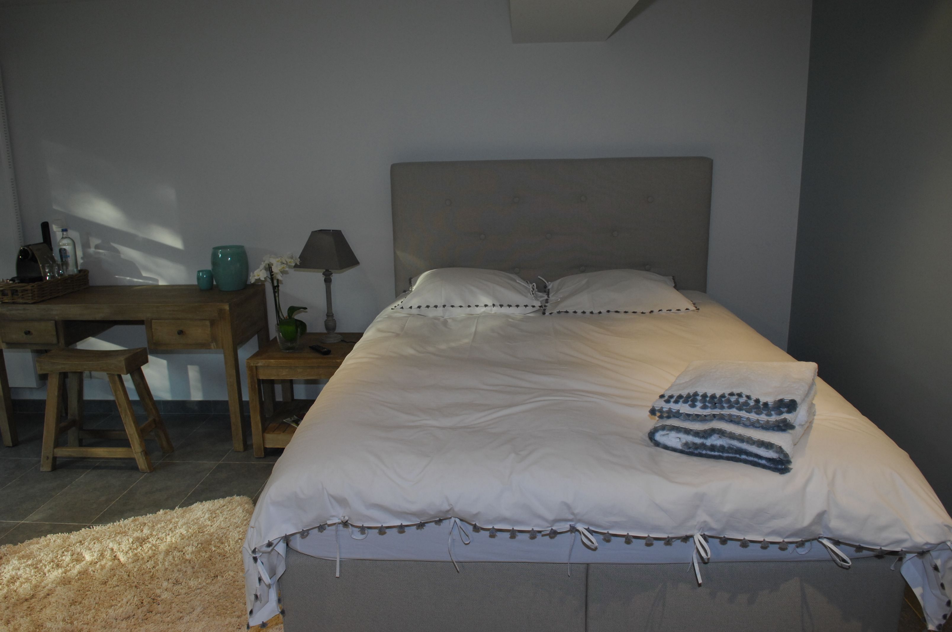 A bedroom with a bed, a desk, and a chair.