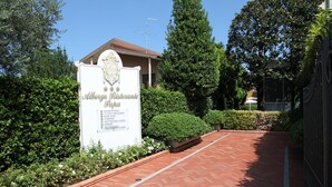A sign for "Alberto Ristorante Bottega" with contact information and a brick pathway leading to the entrance. - Albergo Ristorante Papa (Peschiera del Garda)