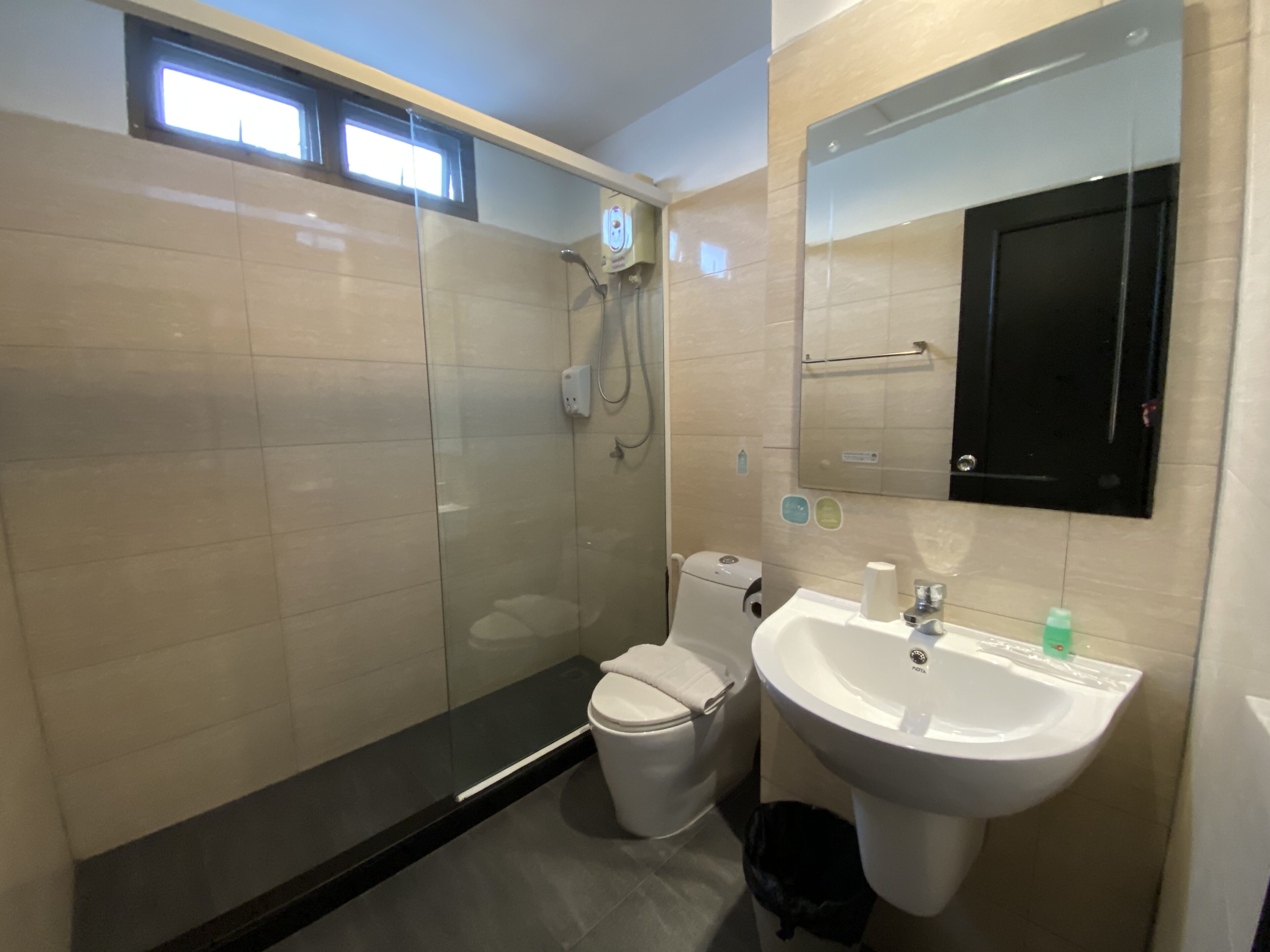 A modern bathroom with a glass-enclosed shower, a toilet, and a sink.
