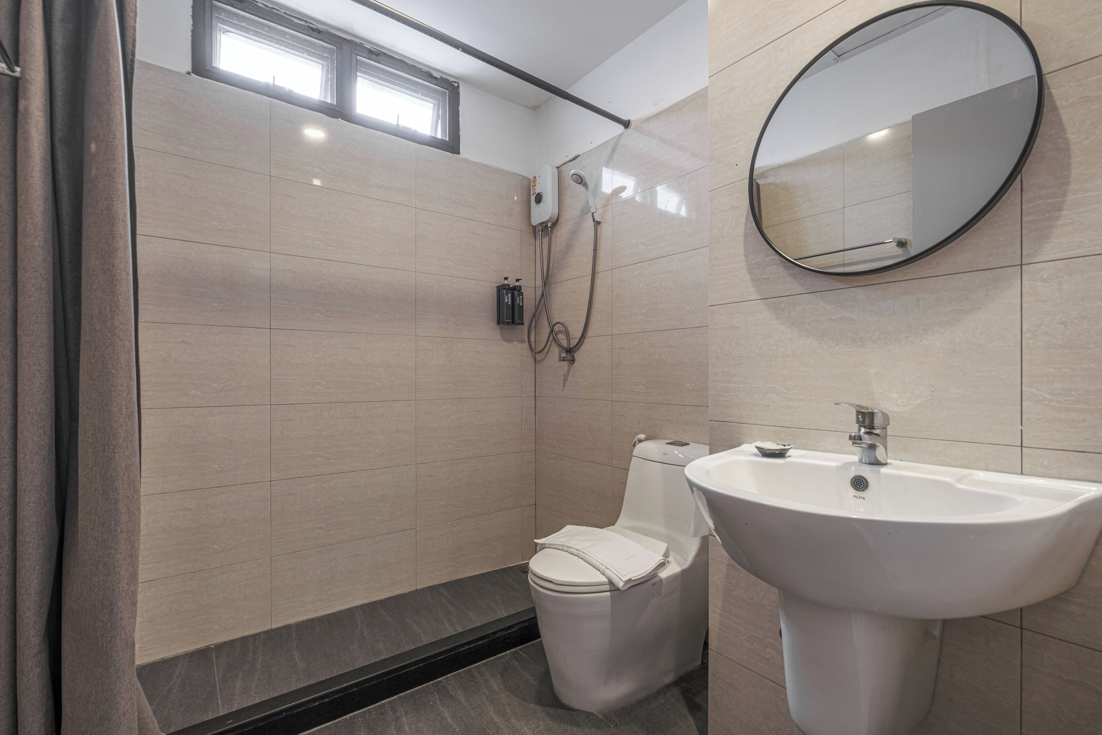 Un baño moderno con inodoro, lavamanos y ducha.
