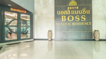 A clean, modern lobby with a sign for 'Mansion Residence' and two decorative vases.