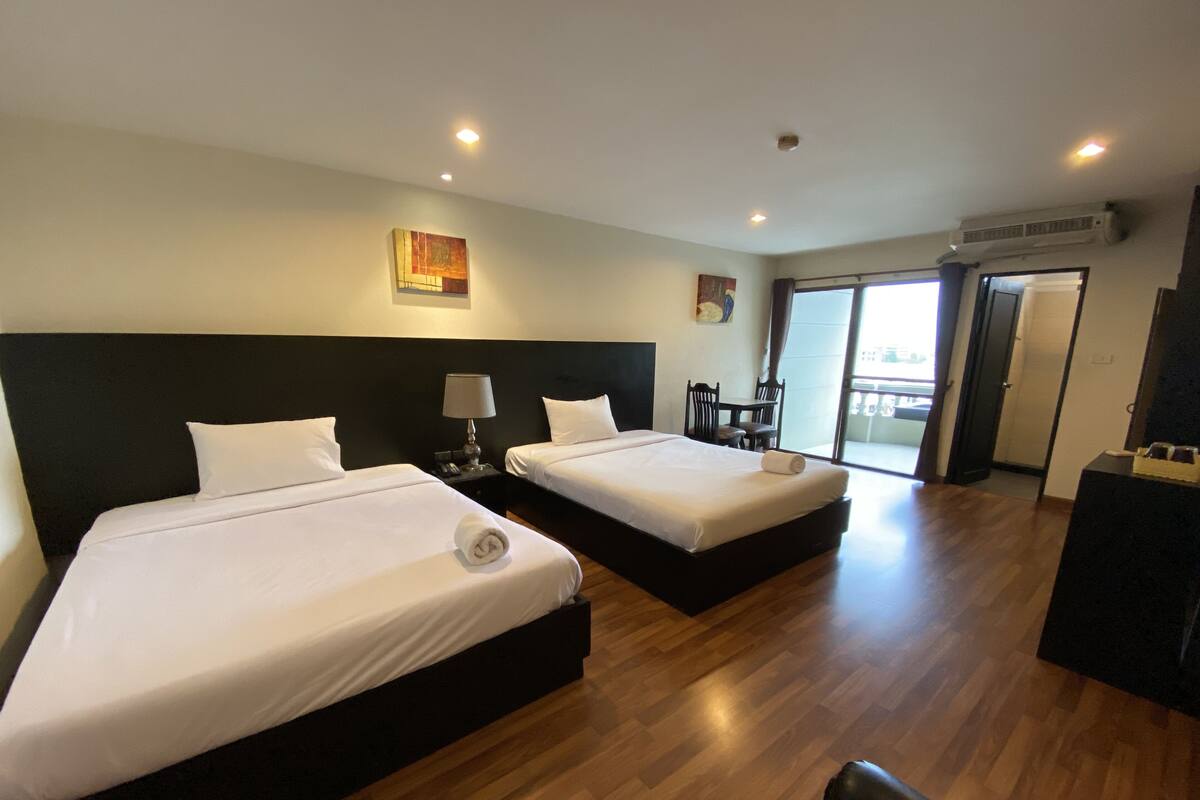 Habitación de hotel con dos camas, un escritorio y una silla.