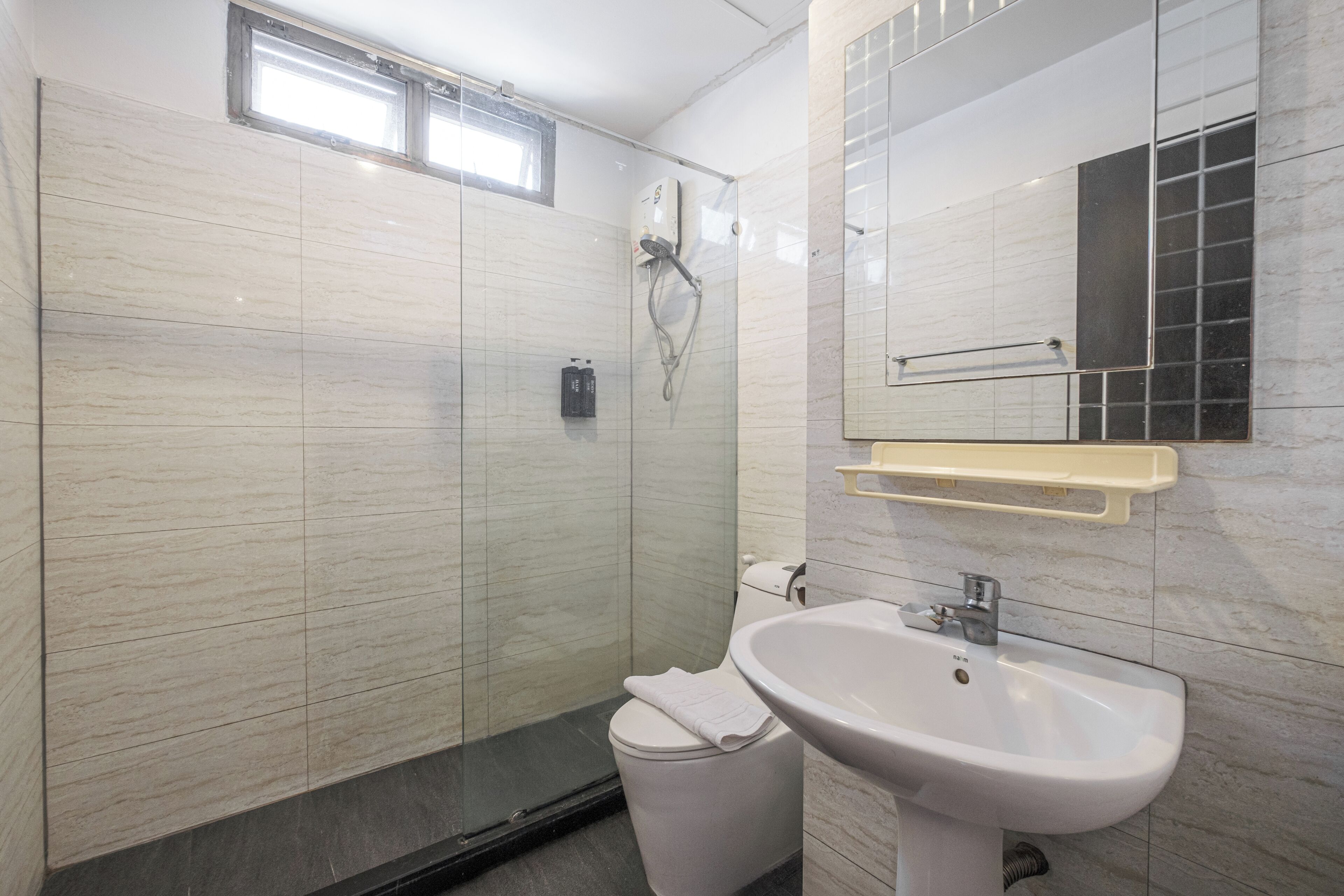 A modern bathroom with a shower, toilet, and sink.