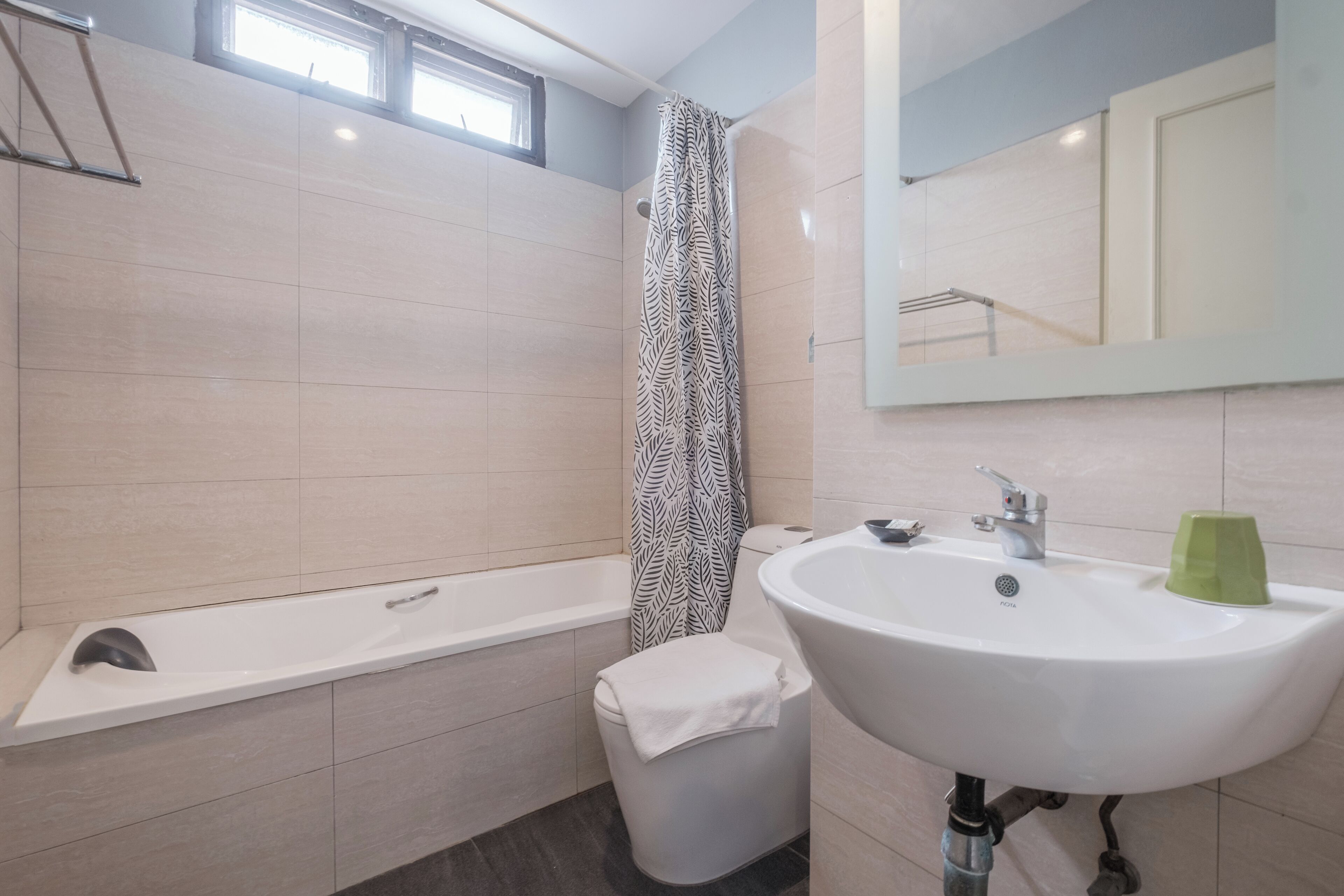 A modern bathroom with a bathtub, toilet, and sink.