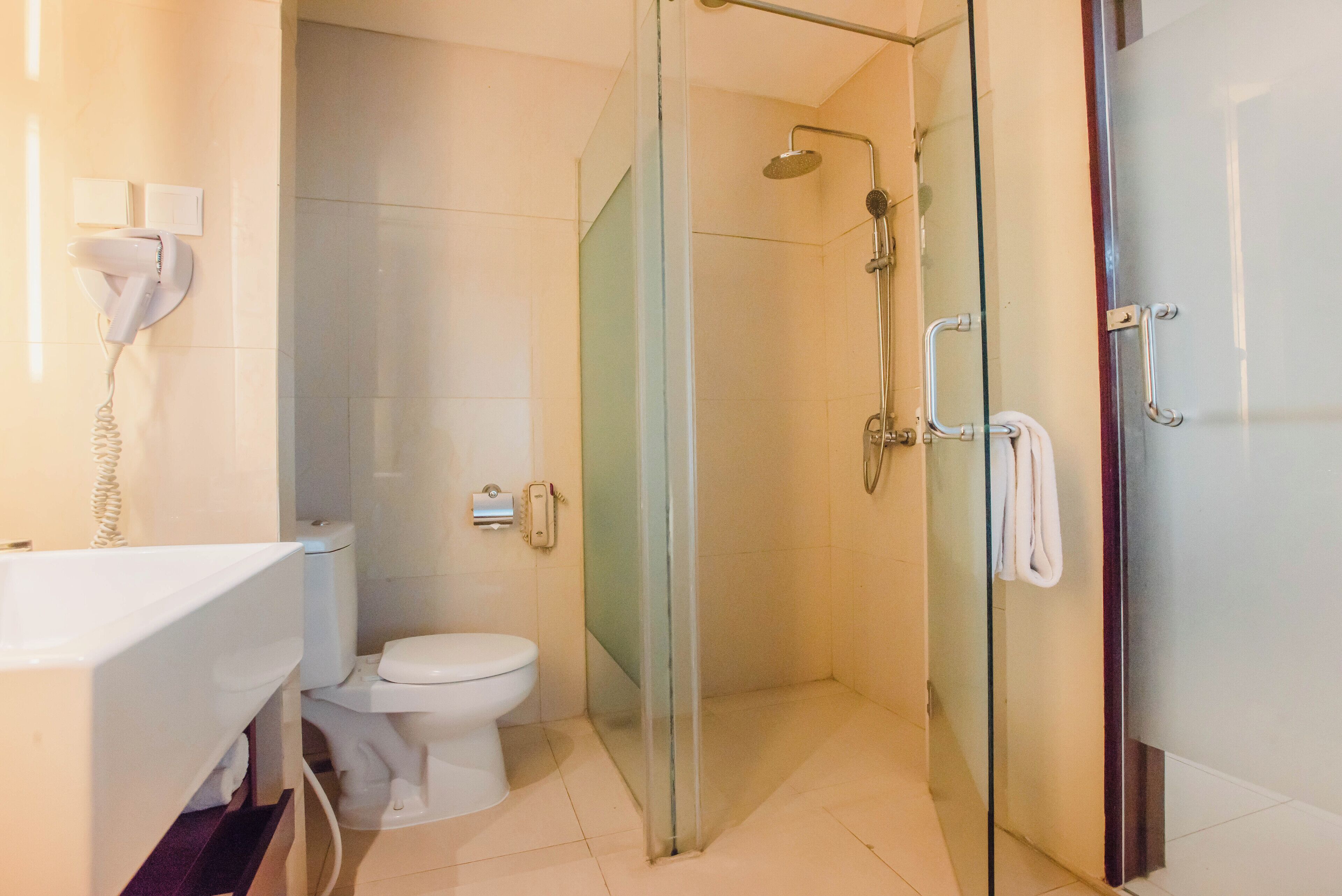 A modern bathroom with a glass-enclosed shower, a toilet, and a sink.