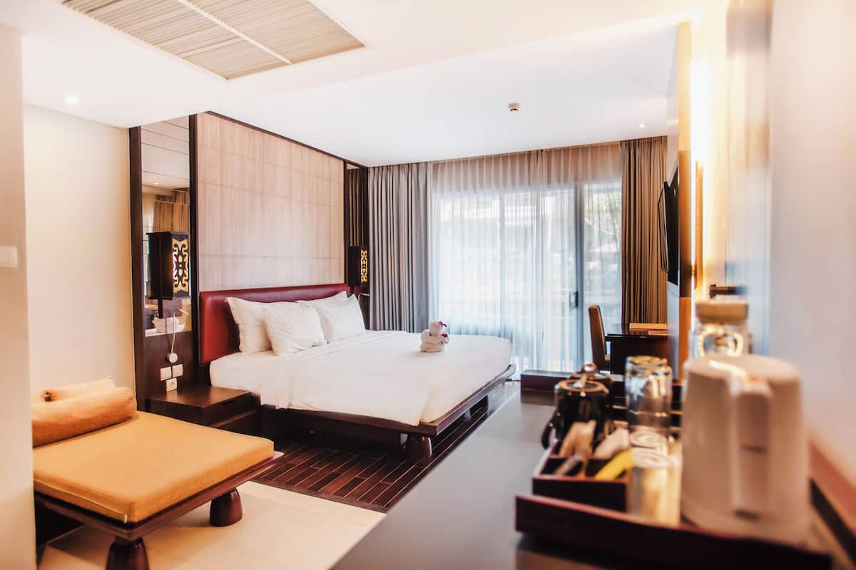Een moderne hotelkamer met een groot bed, een zithoek en een koffiehoek.