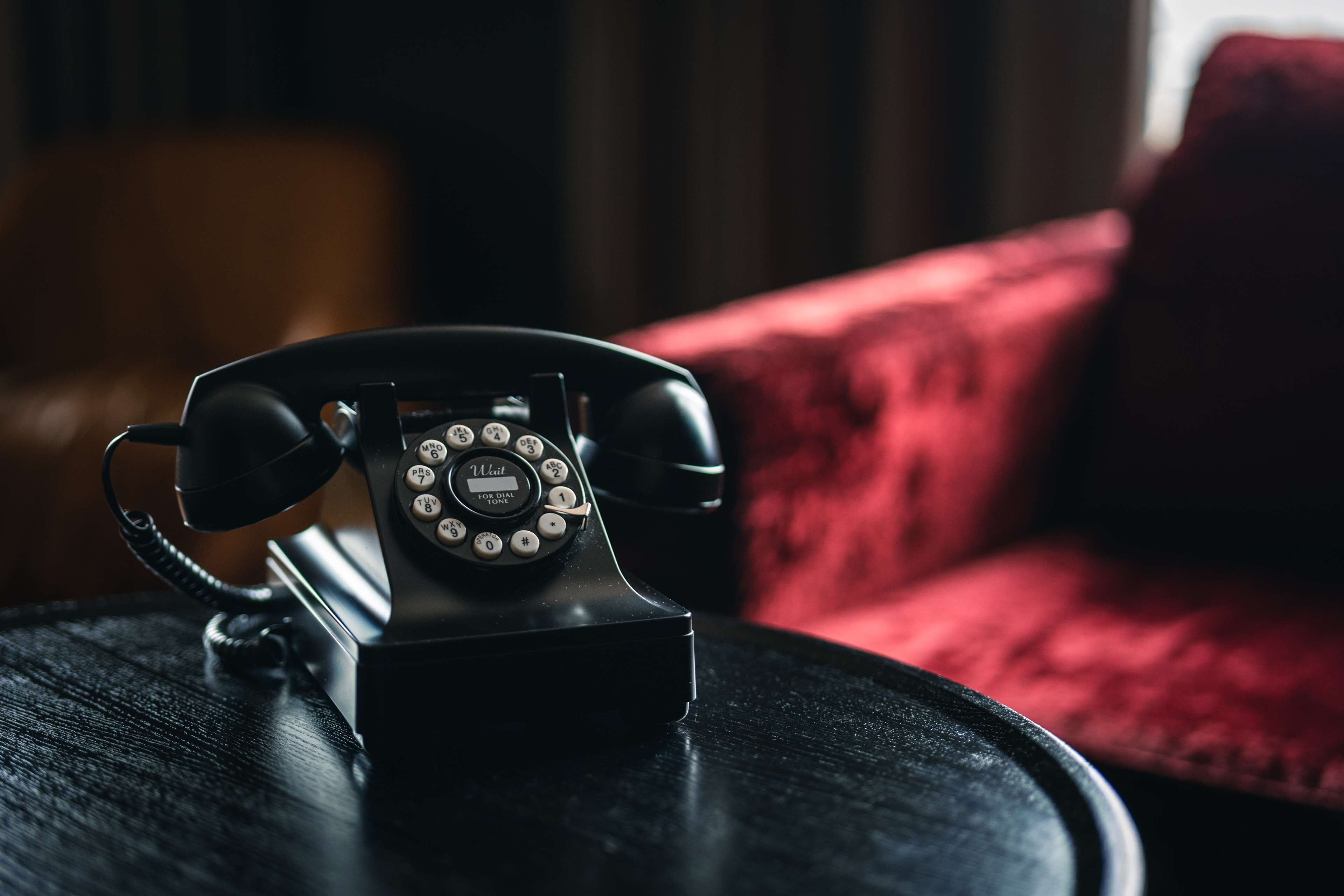 A rotary dial telephone on a round table.