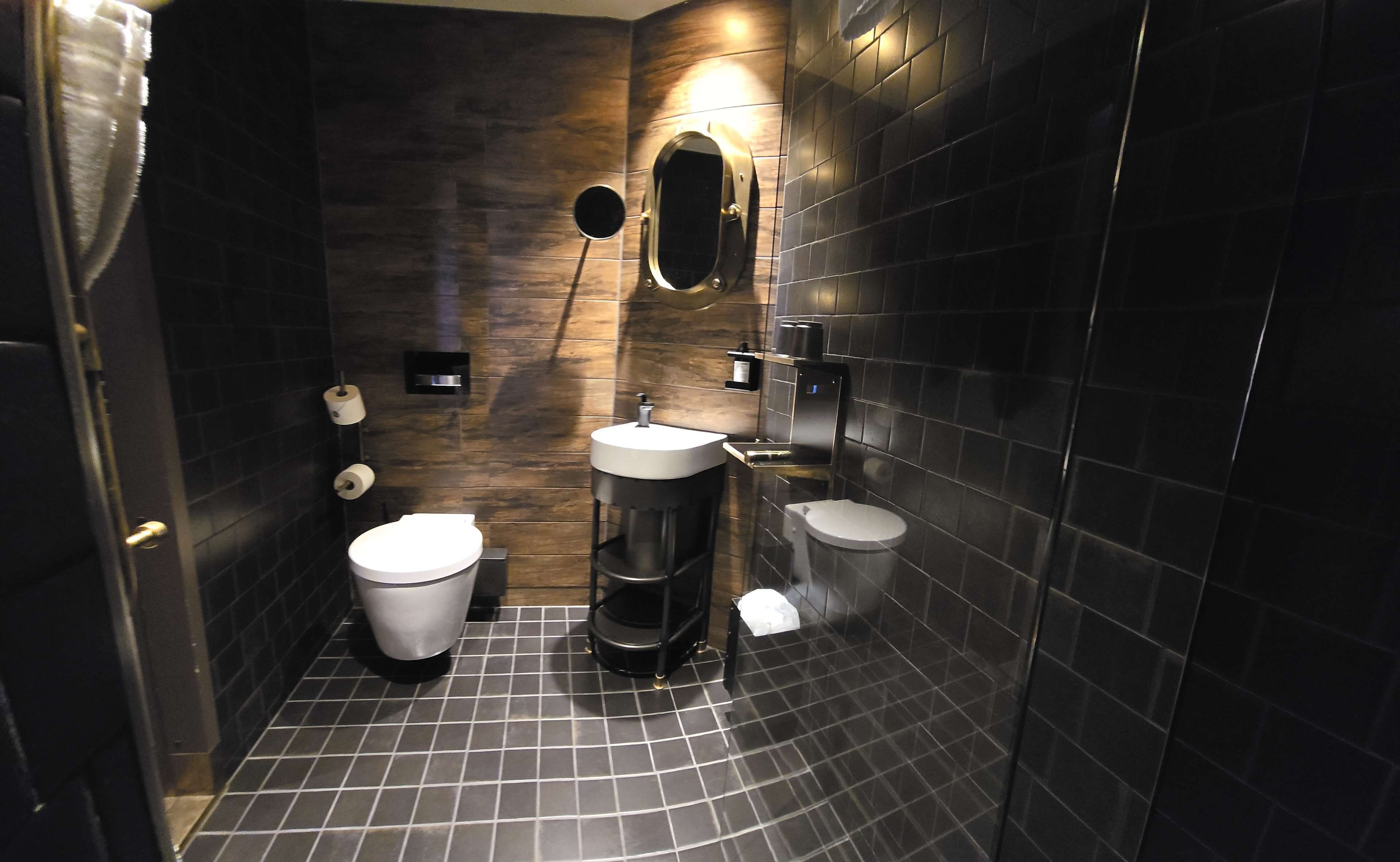 A modern bathroom with a toilet, sink, and bidet.