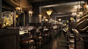 A restaurant with dark wood furniture, chandeliers, and a marble floor. - Stora Hotellet, BW Premier Collection (Umea)