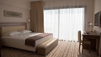 Habitació d'hotel amb un llit gran, una taula i una cadira.