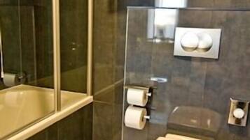 A modern bathroom with a glass shower enclosure, a toilet, and a sink.