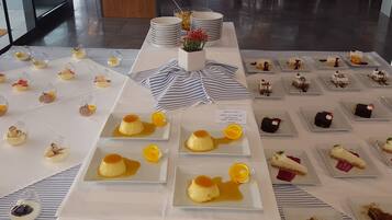 A dessert buffet with various plated sweets and a floral centerpiece.