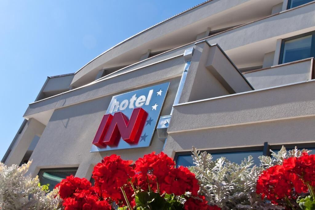 Un letrero de hotel con el nombre 'hotel IN' y un símbolo de estrella.