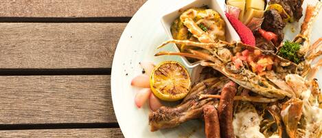 A plate of seafood and meat dishes on a wooden table.