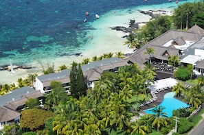 A resort with a swimming pool, beachfront view, and thatched-roof buildings. - Solana Beach - Adults Only (Belle Mare)