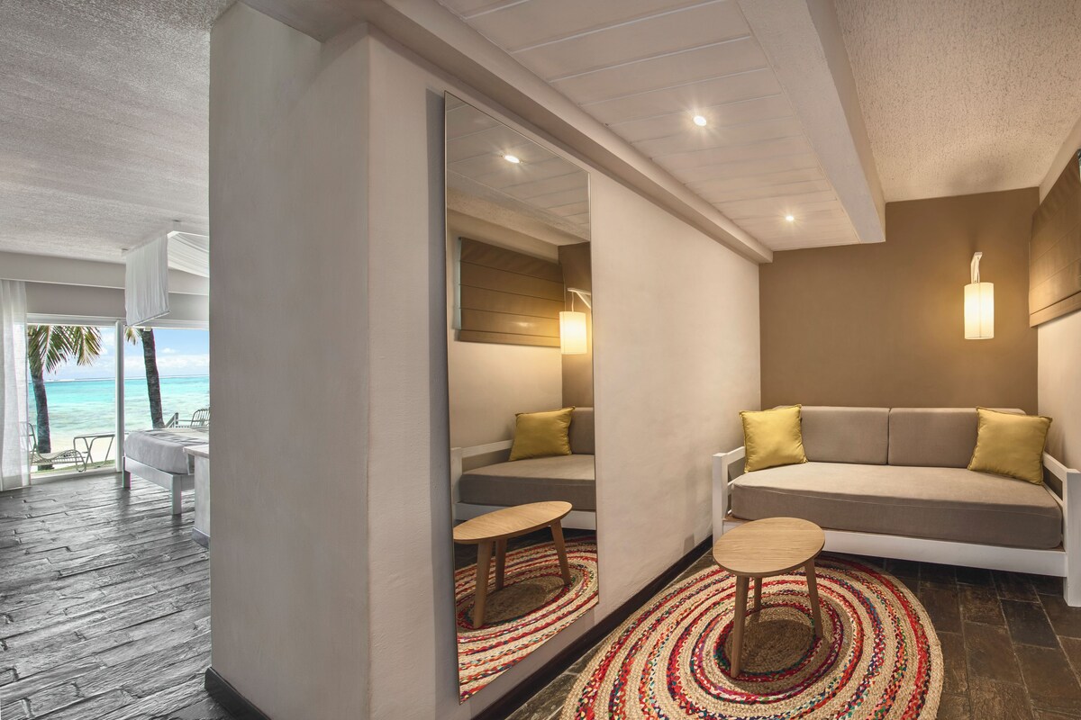 Een moderne woonkamer met een bank, een bijzettafeltje en een kamerkleed met een patroon.
