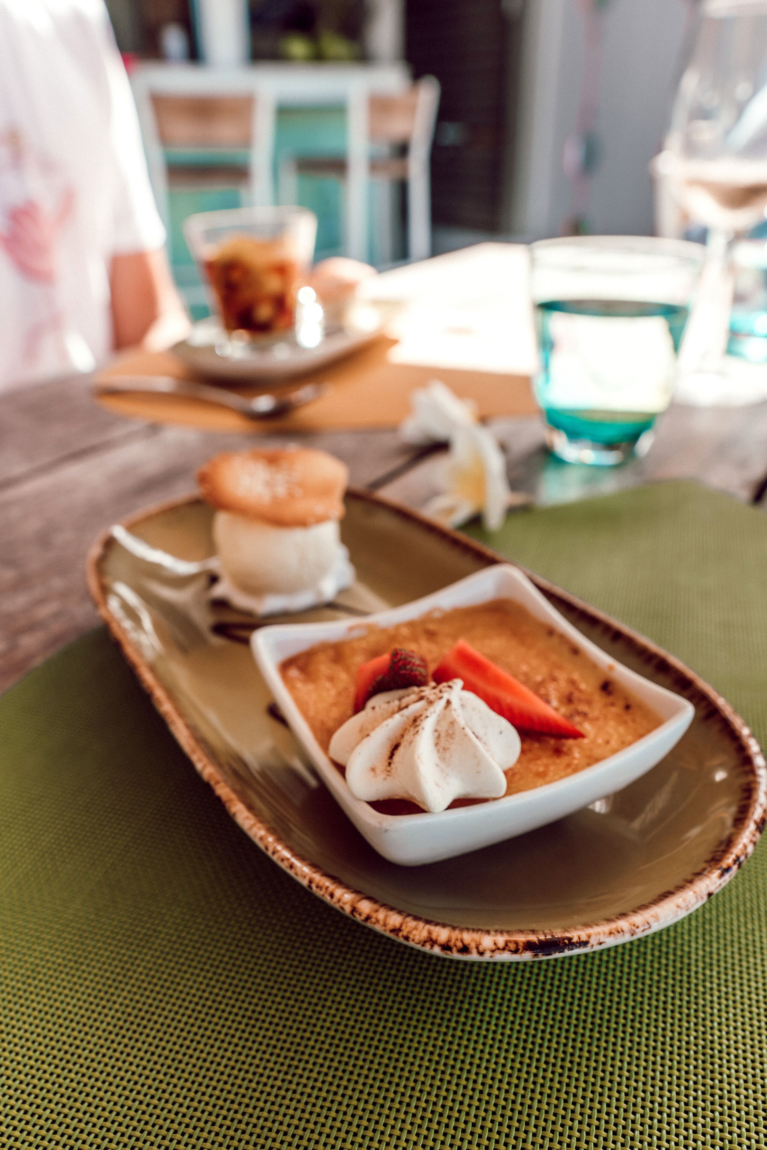 Un plat ceràmic amb una safata de postres, una bola de gelat, un pastís i una cobertura de fruita.