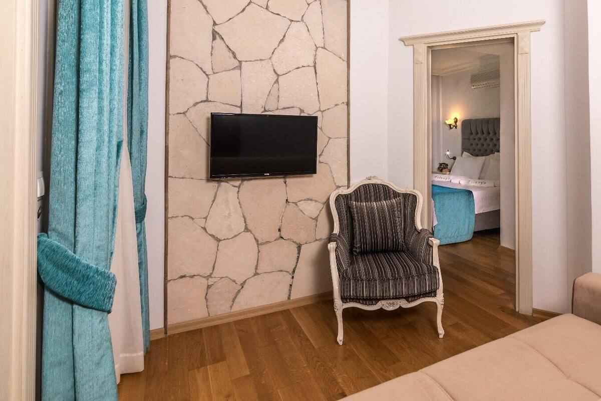 Junior Suite Room with Balcony  | Living area | 27-inch TV with satellite channels, books