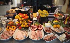 A buffet table with various food items including meats, cheeses, fruits, and condiments. - Hotel Mölndals Bro (Mölndal)