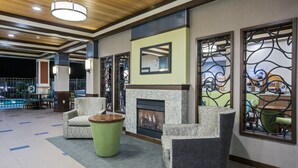 Un hall con chimenea, zona de estar y vista a la piscina.