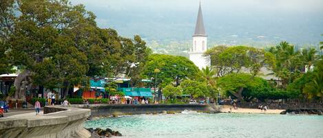 Una zona costera con una iglesia, playa y paseo marítimo.