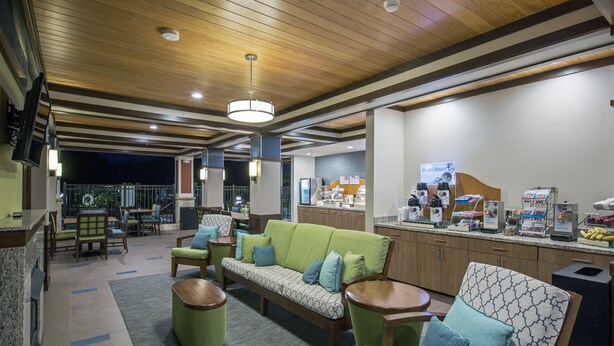 Un área de estar moderna con sofá, sillas y estación de café.