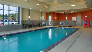 An indoor swimming pool with clear glass walls, a pool lift, and a few lounge chairs. - Hampton Inn & Suites Portland/Vancouver (Vancouver)