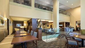 A hotel lobby with multiple dining areas, a staircase, and a bar/lounge area. - Hyatt Place Washington DC/US Capitol (Washington)