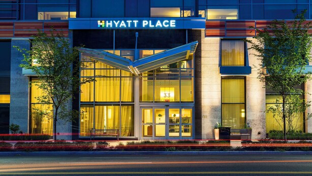 A Hyatt Place hotel entrance with a glass facade, a prominent entrance canopy, and a number '33' sign. - Hyatt Place Washington DC/US Capitol (Washington)