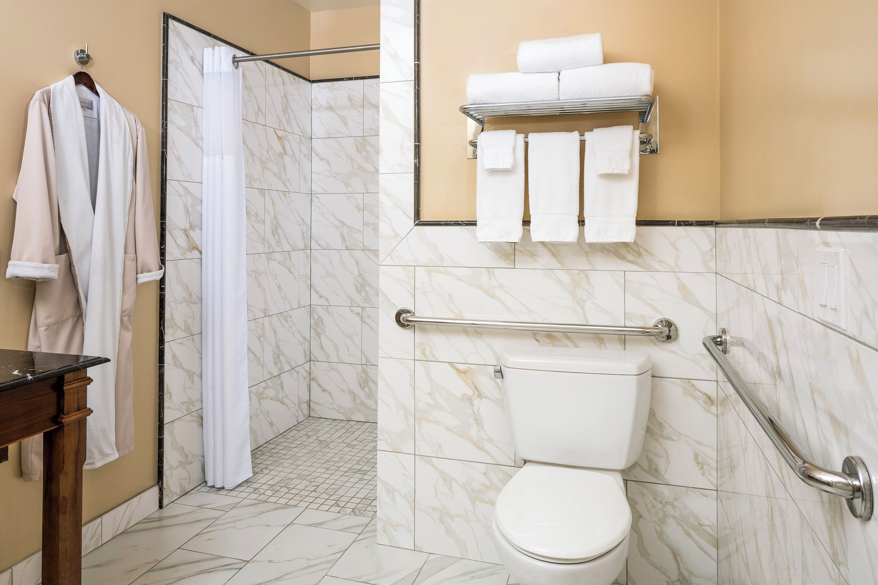 A bathroom with a toilet, shower, and towel rack.