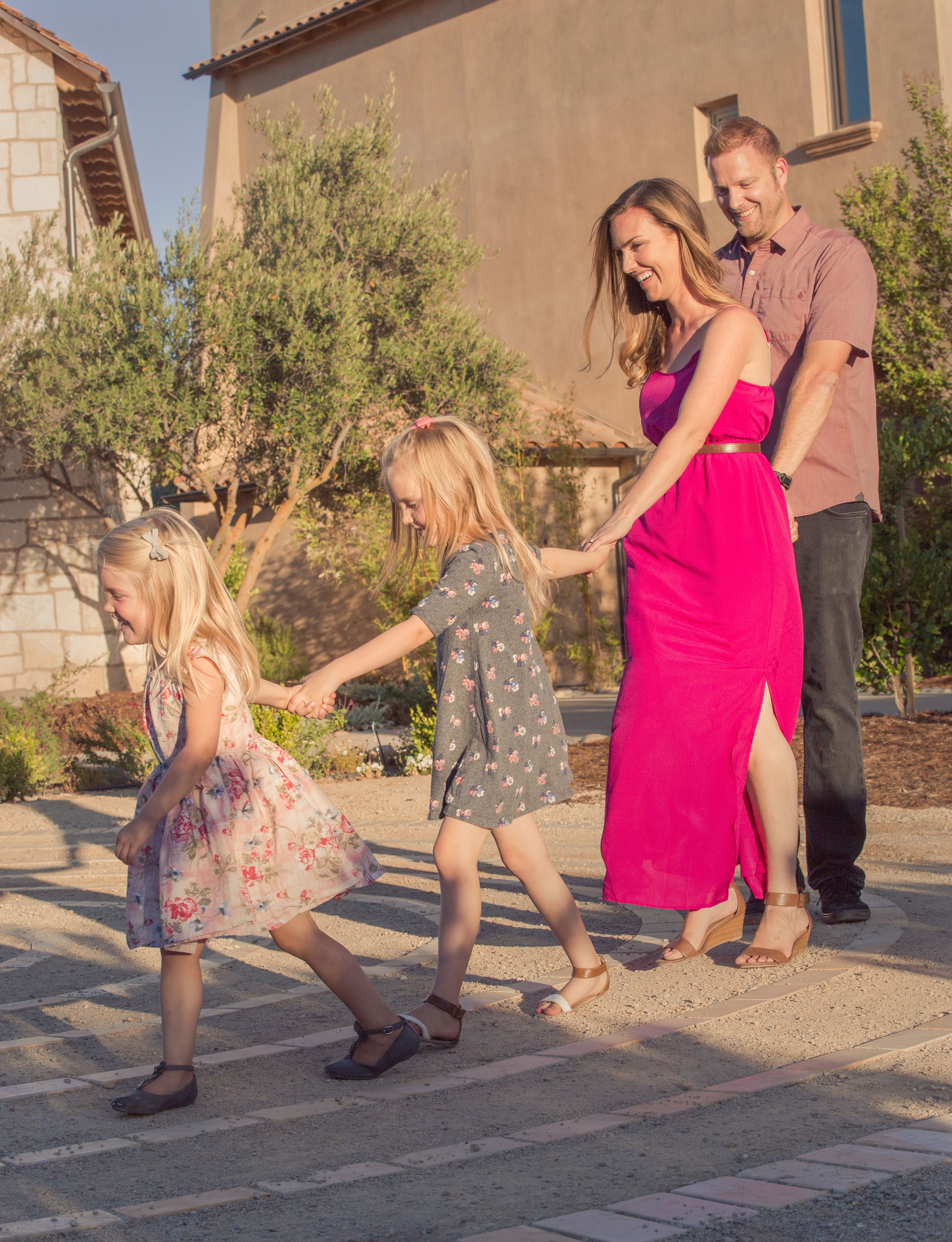 A family walking on a paved path with a building in the background.