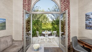 Une pièce dotée d’une porte vitrée donnant sur un patio extérieur aménagé avec une table et des chaises, un canapé et un bureau.