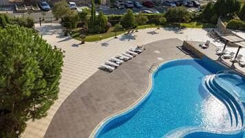 Relax by the pool in a serene outdoor oasis with lounge chairs and umbrellas.