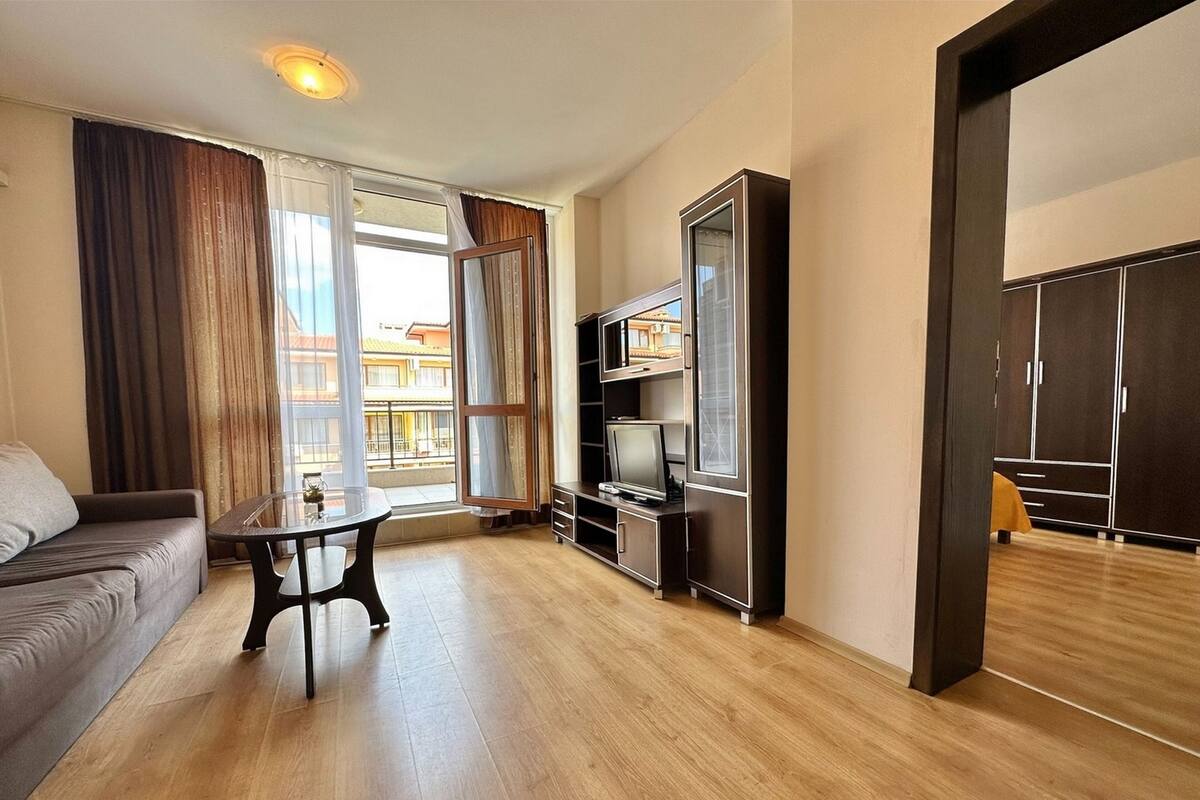 A modern living room with a sofa, a table, a TV, and a wardrobe.