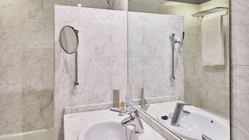 Een moderne badkamer met een wit wastafelmeubel, een spiegel en een douche.