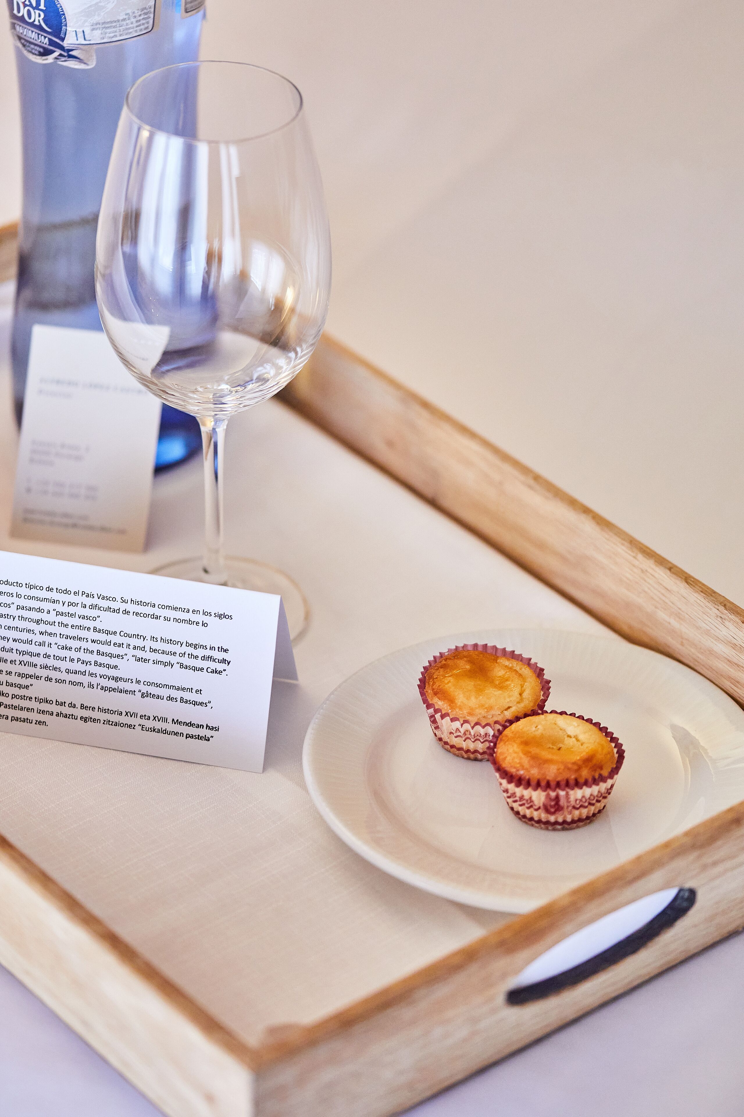 A tray with a glass of water, two pastries, and a menu.