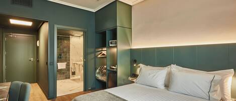 A hotel room with a bed, a chair, a walk-in closet, and a bathroom.