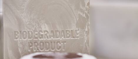 A close-up of a white, biodegradable product with embossed text.