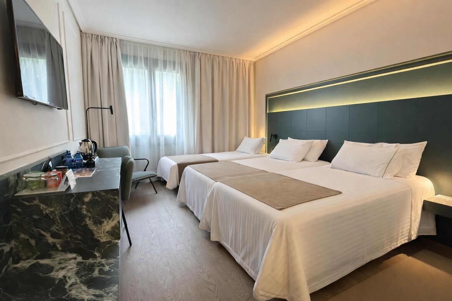 Deluxe Triple Room | Minibar, desk, laptop workspace, iron/ironing board