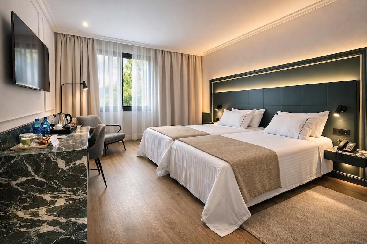 Deluxe Room, Garden View | Minibar, desk, laptop workspace, iron/ironing board