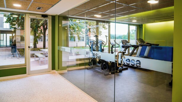 A modern office space with glass walls, a treadmill, and a bench. - Albergue Residencia Universitaria Resa Los Abedules - Campus Accomodation (Pamplona)