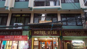 En bygning med flere etager, med restaurant og bar i stueplan, og hotellet "HOTEL UTSE" på anden sal.